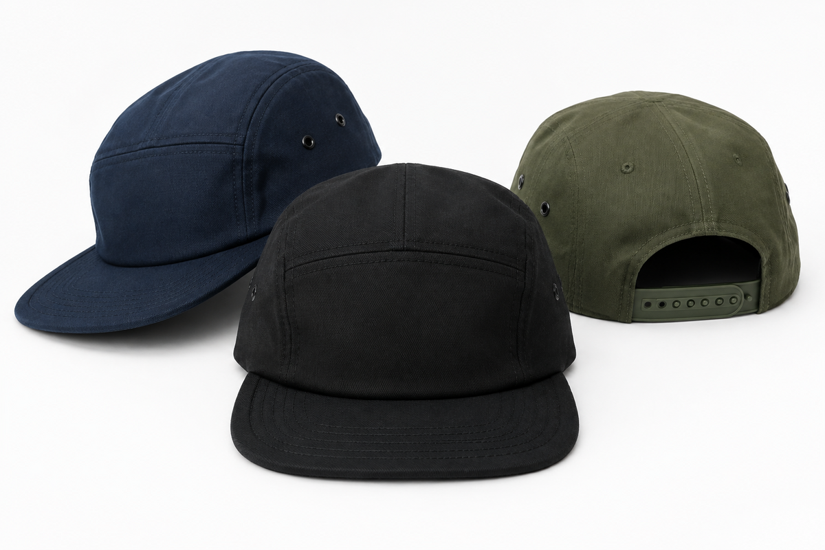 Navy, black and olive green 5-panel caps with flat brims and snapback strap on white background